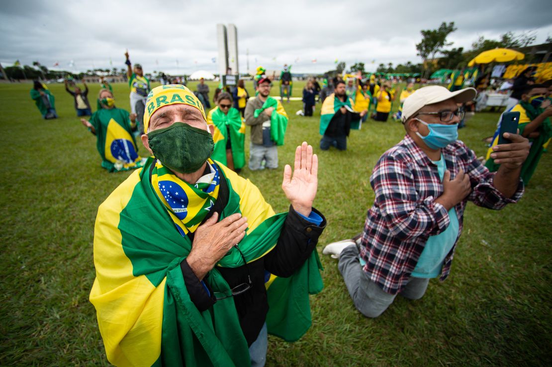 Supporters of Brazilian President Jair Bolsonaro pray during a motorcade and protest against the National Congress and the Supreme Court over lockdown measures amidst on the coronavirus (COVID-19) pandemic in front the National Congress on May 09, 2020 in Brasilia.