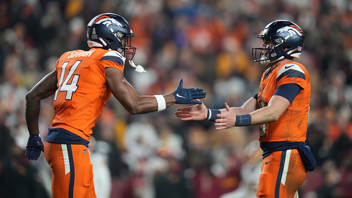 Bo Nix shakes hands with Courtland Sutton